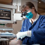A staff member cleaning a patient's teeth